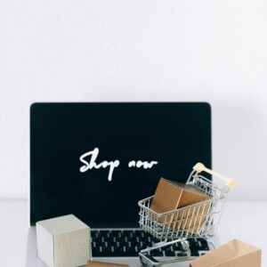 Minimalist online shopping setup with laptop, cart, and packages symbolizing e-commerce.